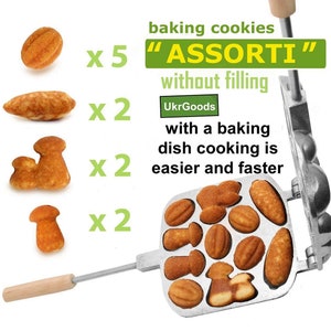 May include: A metal baking pan with a wooden handle. The pan has 12 molds in the shape of nuts, mushrooms, and other shapes. The text "ASSORTI" is printed on the pan in green letters. The text "baking cookies without filling" is printed on the pan in green letters. The text "UkrGoods" is printed on the pan in green letters. The text "with a baking dish cooking is easier and faster" is printed on the pan in green letters.