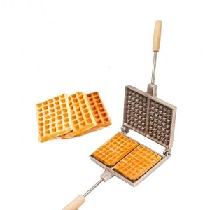 May include: A silver waffle iron with a wooden handle. The iron is open and two waffles are being cooked. The waffles are golden brown and have a square pattern.