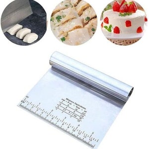 May include: A stainless steel pastry scraper with a ruler and measurement conversions for cups, tablespoons, and milliliters. The scraper has a rounded handle and a flat, rectangular blade.