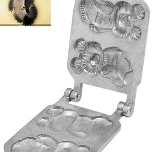 May include: A vintage metal waffle iron with a bear design. The iron is silver-colored and features a hinged design with bear-shaped molds. An illustration of the bear is in the upper left corner.