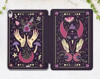May include: A dark purple tablet case with a mystical design. The case features illustrations of hands, mushrooms, moons, stars, and a central design of a bird skull with a crystal. The design is in shades of pink, yellow, and white.