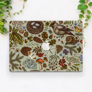Op de afbeelding: Een laptop-skin met een kleurrijk, door de natuur geïnspireerd ontwerp. De skin bevat een verscheidenheid aan illustraties, waaronder vogels, vlinders, paddenstoelen, dennenappels, bladeren en bloemen. De achtergrond is lichtgroen.