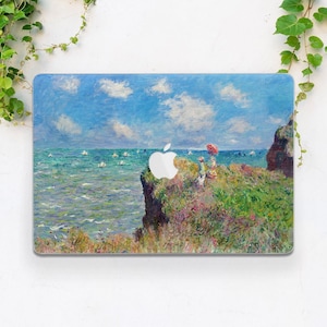 May include: A laptop skin with a painting of a seascape with a cliff and two figures in the foreground. The sky is blue with white clouds and the sea is a light blue with whitecaps. The painting is in a style reminiscent of Impressionism.