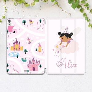 Könnte beinhalten: Eine rosa und weiße Tablethülle mit einem Feenprinzessinnen-Design. Die Vorderseite der Hülle zeigt eine Comic-Feenprinzessin mit schwarzen Haaren und einem rosa Kleid, die auf einer Wolke fliegt und Glitzer verstreut. Die Rückseite der Hülle zeigt eine rosa und weiße Karte mit Schlössern, Einhörnern und anderen märchenhaften Elementen. Die Hülle ist mit dem Namen "Alice" personalisiert.