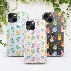 Puede incluir: Tres fundas transparentes para teléfono con diseños de temática de Pascua. Las fundas presentan colores pastel, conejos y huevos.