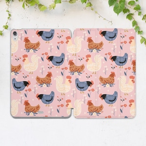 以下が含まれることがあります： ピンクのiPadケースで、カラフルな鶏と花が繰り返し描かれたパターンになっています。ケースは耐久性のある素材で作られており、画面を覆うフラップが付いています。
