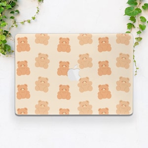 May include: A beige laptop skin with a repeating pattern of brown teddy bears. The bears are all facing forward with their arms outstretched.