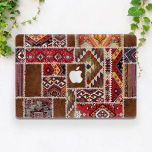 May include: A laptop skin with a patchwork design featuring various red, brown, blue, and green geometric patterns. The skin has a stitched look, giving it a vintage feel.