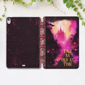 Könnte beinhalten: Eine iPad-Hülle in Lila und Gold mit einem Vintage-Buchdesign. Die Hülle zeigt im Hintergrund ein Schloss und den Text "Tale as old as time".