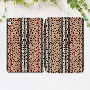 May include: An open tablet case featuring a tan leopard print design with black, gray, and red vertical stripes. The case is made of a textured material and has a sleek, modern look. The case is designed to protect the tablet.