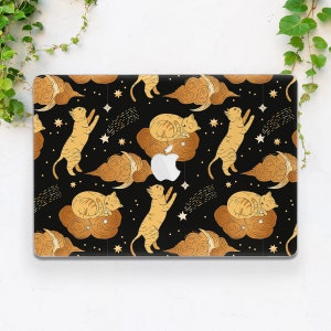 May include: A black laptop skin with a gold pattern of cats and clouds. The cats are in various poses, some sleeping and some reaching for stars. The clouds are stylized and have a crescent moon shape. The skin is designed to fit a standard laptop.