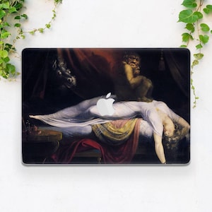 May include: Laptop skin featuring a detail from a painting depicting a woman in a white gown, lying on a bed. A dark figure and a creature are positioned above her. The Apple logo is visible on the laptop skin.
