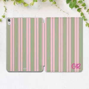 Könnte beinhalten: Eine offene Tablet-Hülle mit vertikalem Streifenmuster in Rosa und Olivgrün. Die Initialen "GR" sind in Rosa unten rechts. Die Hülle dient zum Schutz eines Tablets.