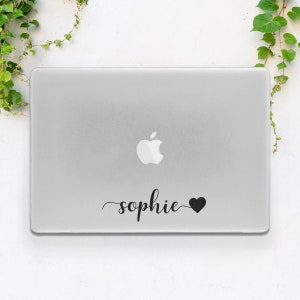 May include: A white laptop computer with a black apple logo and a black sticker that says "sophie" with a heart.