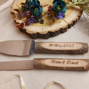 Könnte beinhalten: Ein Set aus zwei Kuchenspachteln mit Holzgriffen. Die Griffe sind mit dem Text "18. Mai 2022" und "Helen & David" graviert.