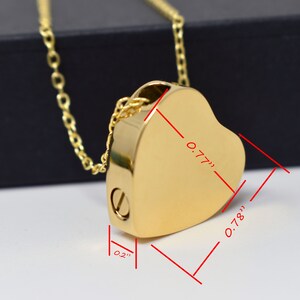 May include: A gold-colored heart-shaped pendant necklace. The pendant measures 0.77 inches wide, 0.78 inches high, and 0.2 inches thick. The necklace has a delicate chain and a screw closure on the side.