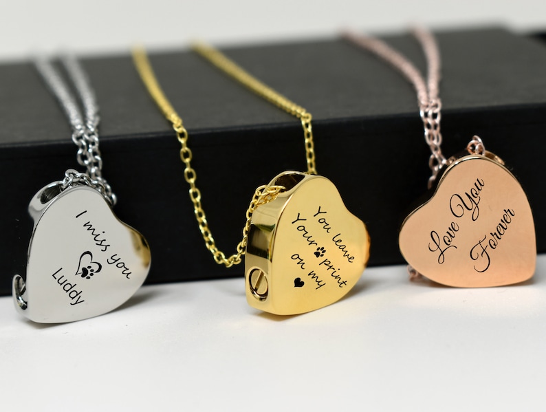 May include: Three heart-shaped pendant necklaces in silver, gold, and rose gold. Each pendant has a different inscription: "I miss you Luddy", "You leave your print on my", and "Love You Forever".