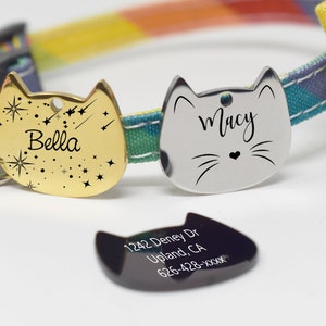 May include: Two gold and silver cat-shaped pet ID tags with the names Bella and Macy engraved on them. A black tag with the text 1242 Deney Dr Upland, CA 626-428-XXXX is also shown.