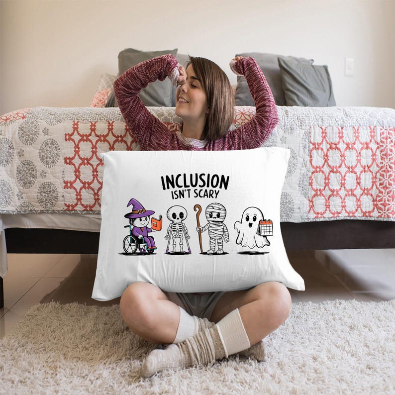 May include: White pillow with the text "Inclusion Isn't Scary" and a cartoon illustration of a witch in a wheelchair, a skeleton, a mummy, and a ghost.