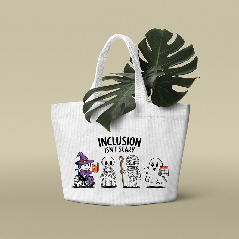 May include: White canvas tote bag with the text "Inclusion isn't scary" and a graphic of four Halloween characters: a witch in a wheelchair, a skeleton with crutches, a mummy with a cane, and a ghost holding a calendar.