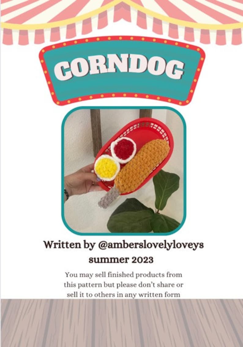 May include: A crocheted corndog with mustard and ketchup in a red plastic tray. The image has the text "CORNDOG" at the top and "Written by @amberslovelyloveys summer 2023" at the bottom.