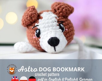 May include: Crochet pattern for an Astro Dog bookmark. The pattern is available in English, Polish, and German. The bookmark is brown, white, and black with a cute dog face.