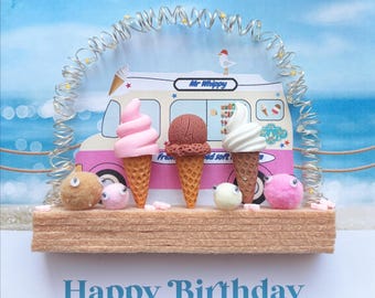 May include: A whimsical birthday card featuring an ice cream truck with three ice cream cones in pink, brown, and white. The card includes the text "Happy Birthday" in blue script, with decorative elements.