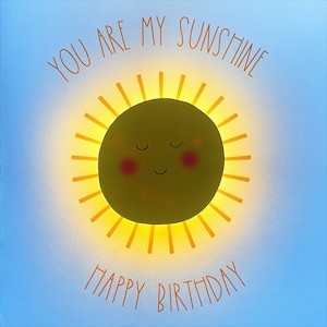 May include: A yellow sun with a smiling face and closed eyes, surrounded by yellow rays. The text "You are my sunshine" is above the sun and "Happy Birthday" is below the sun.