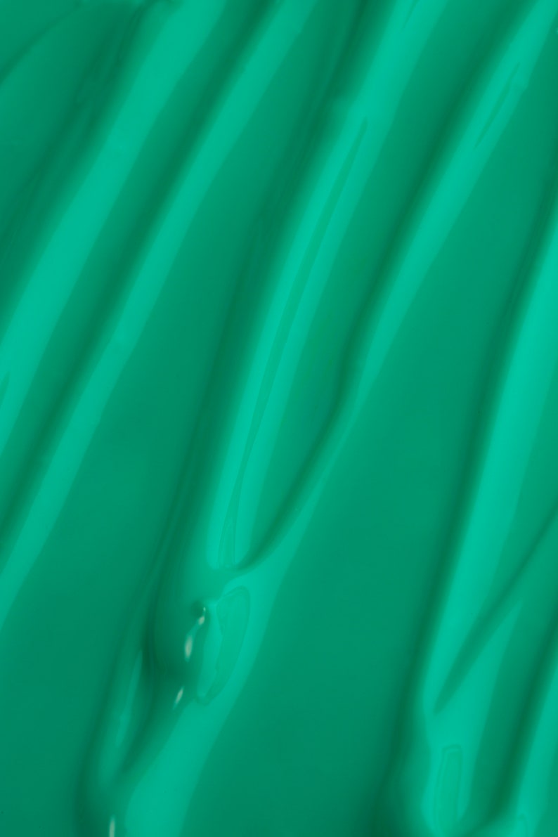 May include: A close-up of a smooth, teal green surface with a rippled texture.