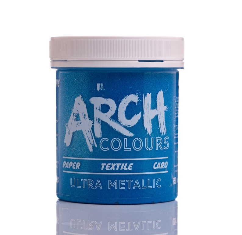 May include: A blue jar of paint labeled "Arch Colours Ultra Metallic". The jar has a white lid and the label also says "Paper, Textile, Card".