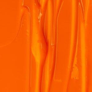 May include: Close-up of a smooth, bright orange surface with a rippled, textured pattern. The surface is shiny and reflects light.