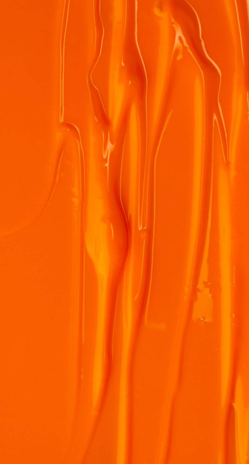 May include: Close-up of a smooth, bright orange surface with a rippled, textured pattern. The surface is shiny and reflects light.