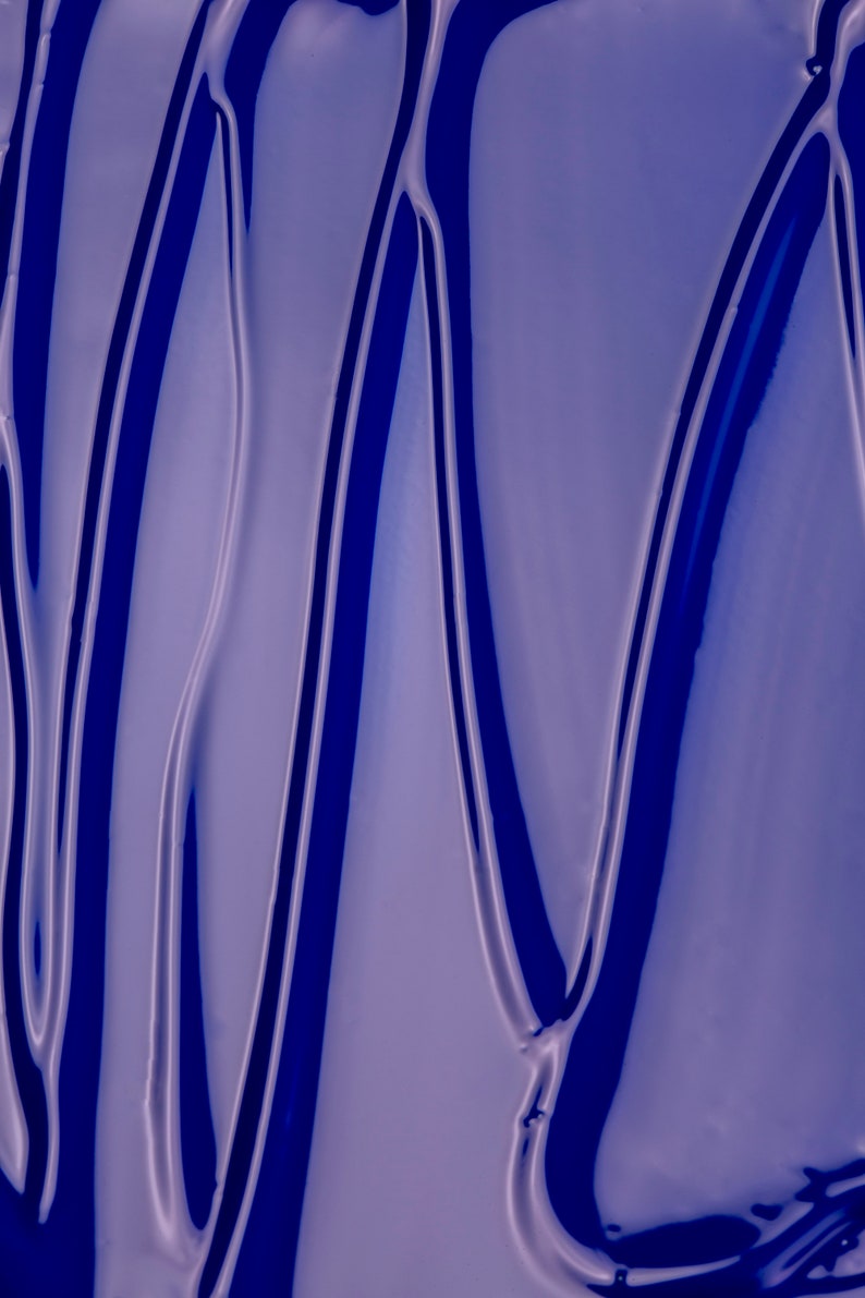 May include: Close-up of a blue, glossy, liquid surface with wavy lines and a smooth, reflective texture.