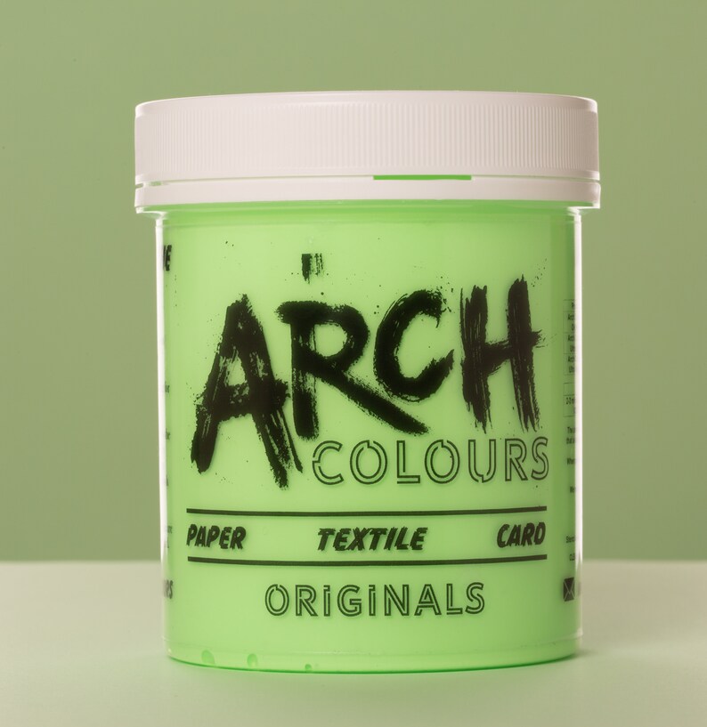 May include: A green plastic jar of paint with a white lid. The jar is labeled "ARCH COLOURS" in black lettering. The jar also says "PAPER, TEXTILE, CARD, ORIGINALS" in black lettering.