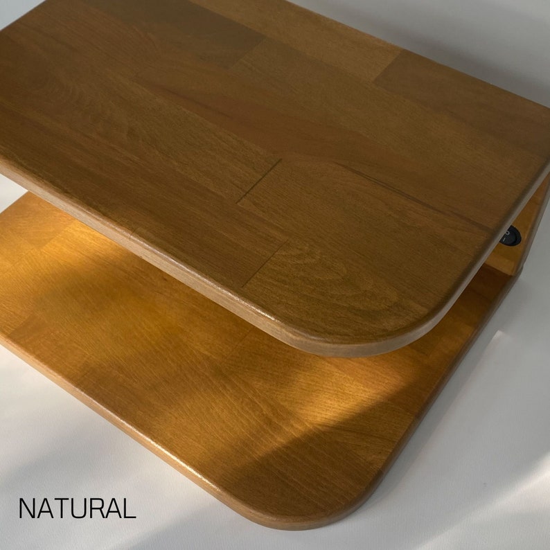 May include: A two-tiered wooden shelf with rounded edges. The shelf is made of natural wood and has a light brown color. The shelf is labeled "NATURAL".