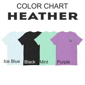 Op de afbeelding: Kleurenkaart van heather t-shirts in ijsblauw, zwart, mint en paars. Het paarse shirt heeft een kleine afbeelding op de borst. De tekst "COLOR CHART HEATHER" staat bovenaan, met de kleurnamen eronder.