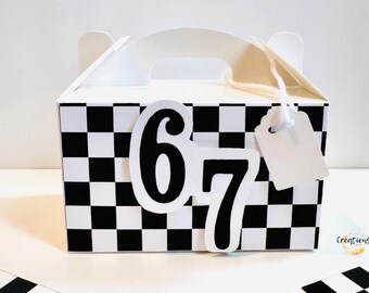 May include: White gift box with a black and white checkered pattern. The number "67" is prominently displayed on the front. A blank white tag hangs from the handle. The box has a handle for easy carrying.