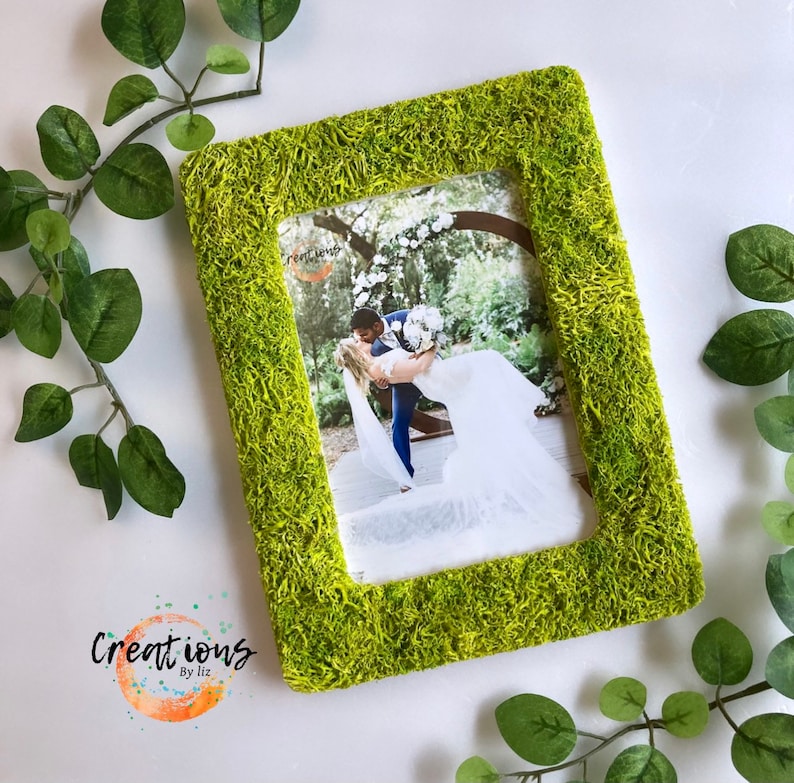 Pu&ograve; includere: Cornice fotografica rettangolare con una vibrante texture verde muschio. La cornice contiene una fotografia di una coppia che si abbraccia. La cornice ha il testo "Creations by liz" nell'angolo in basso a sinistra.