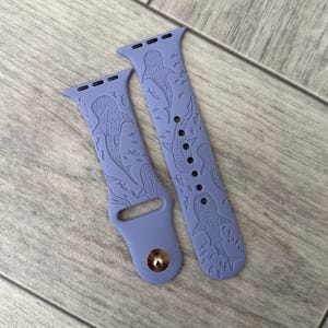 K&ouml;nnte beinhalten: Zwei lavendelfarbene Uhrenarmb&auml;nder mit einem Walhai- und Fischdesign. Die Armb&auml;nder bestehen aus einem flexiblen Material und weisen ein detailliertes gepr&auml;gtes Muster auf. Sie sind f&uuml;r eine Smartwatch konzipiert und haben einen Metallverschluss.