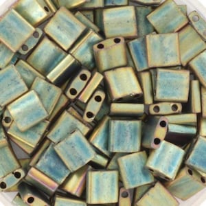 May include: A pile of iridescent, rectangular beads in teal, gold, and bronze hues. Each bead has two holes for threading and a gently curved form. These beads are suitable for jewellery making.