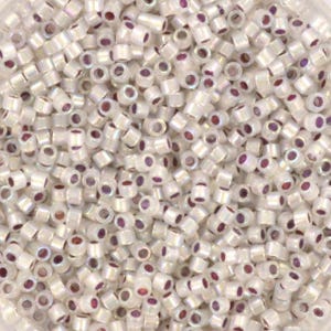 May include: A large quantity of small, white, round seed beads with an iridescent shimmer and a purple centre.