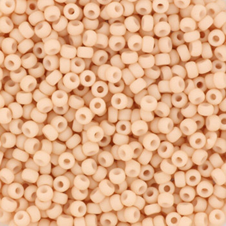 May include: A large quantity of small, round, opaque, light peach-colored beads.