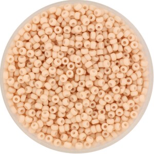 May include: A close-up view of a container filled with small, round, light peach-colored beads. The beads are arranged in a random pattern and appear to be made of glass or plastic.