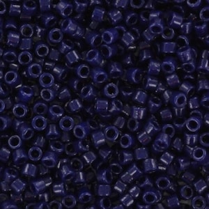 May include: A close-up view of a large quantity of small, dark blue, round seed beads.