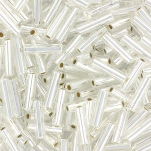 May include: A large pile of clear glass beads with a silver iridescent finish. The beads are cylindrical in shape and have a hole through the centre.