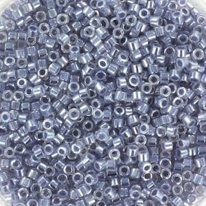 Könnte beinhalten: Nahaufnahme einer großen Menge kleiner, runder, silberfarbener Perlen. Die Perlen haben einen leicht bläulichen, irisierenden Schimmer.