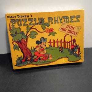 May include: A vintage Walt Disney's "Puzzle Rhymes" box featuring a colorful illustration of Minnie Mouse as Little Miss Muffet. The box is yellow with green, red, and black accents, and includes the text "Little Miss Muffet".