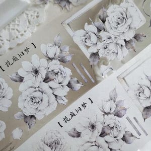 May include: Decorative floral washi tape featuring watercolor-style roses and other flowers in shades of white and gray. The tape includes Chinese characters and the words "romantic color".
