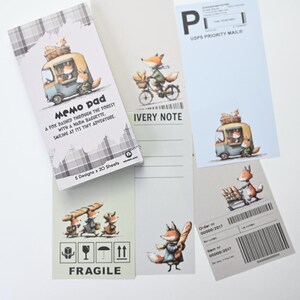 May include: A collection of memo pads and notepaper featuring whimsical illustrations of foxes. The designs include a fox driving a van, riding a bicycle, and carrying a baguette. The memo pad reads "Memo pad" and "A fox dashed through the forest with a warm baguette."