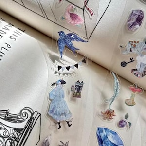 Può includere: Un foglio di adesivi trasparenti con varie illustrazioni. I disegni includono un uccello blu con stelle, una donna in abito blu, una volpe, una gemma blu e altre immagini a tema fantasy. Gli adesivi hanno uno sfondo trasparente.